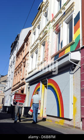 Ein Mann trägt Plakate von der extremistischen Partei NPD aus ein Haus, das von der Polizei in Dortmund, Deutschland, 23. August 2012 gesucht wurde. Die Premiere des North Rhine-Westphalia geächtet heute drei rechten extremistische Organisationen. Polizei wurden in Kraft gegen die Neonazis und Zimmer im Ruhrgebiet und in Aachen gesucht. Die Organisationen "Kameradschaft Aachener Land", Stockfoto