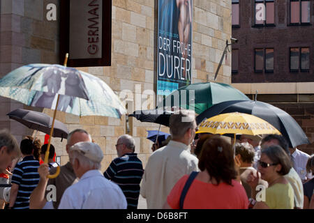 Mit Regenschirmen als Sonnenschutz Gewappnet Stehen if Menschen bin Donnerstag (23.08.2012) in Nürnberg (Mittelfranken) Vor Dem Germanischen Nationalmuseum Schlange Für Die Dürer-Ausstellung. Seit Anfang Mai Haben Bereits Über 200 000 Besucherausweis sterben Golfplätzen, sterben Noch Bis 02.09. Geöffnet ist, gesehen...gabs. Da Immer Nur 400 Besucher Eingelassen Werden, können Die Besucher teils Stockfoto