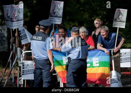 Zwei Polizisten beobachten eine Gruppe von Demonstranten mit Spruchbändern vor der israelischen Botschaft in Berlin, Deutschland, 23. August 2012. Von "Addameer" organisierte Demonstration richtet sich gegen den angeblichen Missbrauch von palästinensischen Gefangenen in israelischen Gefangenen. Foto: ROBERT SCHLESINGER Stockfoto