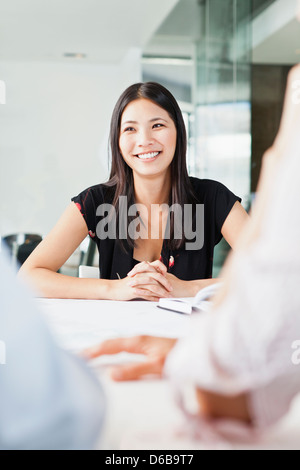 Geschäftsfrau, die lächelnd in treffen Stockfoto