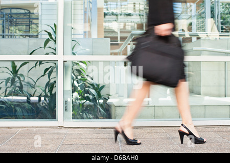 Geschäftsfrau, die zu Fuß auf Stadtstraße Stockfoto