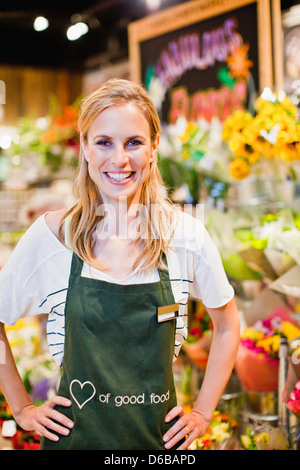 Lebensmittelhändler lächelnd in Florist Abschnitt Stockfoto