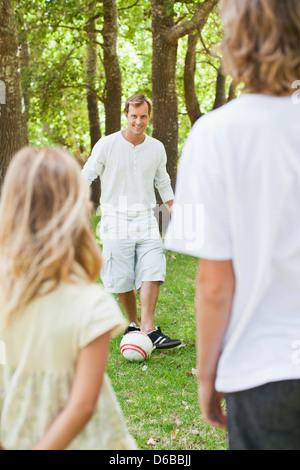 Vater und Kinder spielen im park Stockfoto