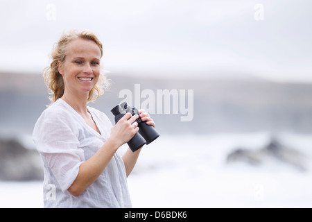 Frau mit dem Fernglas am Strand Stockfoto