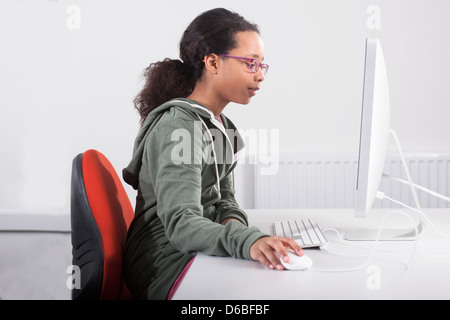 Mädchen mit Computer am Schreibtisch Stockfoto