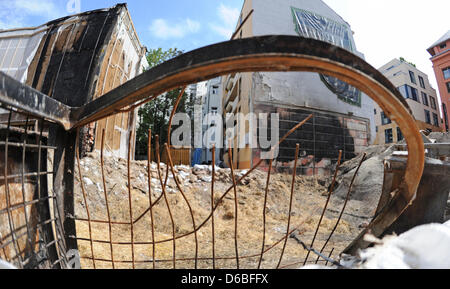 Eine verbogene Metallgitter ist Bilder vor einem Bombentrichter in welche Lügen Stroh in München, 30. August 2012. Aufräumarbeiten nach der kontrollierten Blasring ein US-Flugzeug Bombe haben in München begonnen. Die Druckwelle der Explosion beschädigt mindestens 17 Häuser. Die gute Nachricht: keines der Häuser sind einsturzgefährdet. Foto: MARC Müller Stockfoto