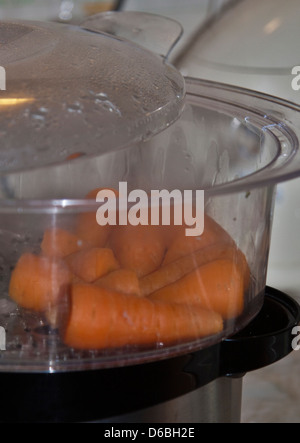 Karotten Kochen in Elektro-Dampfgarers Stockfoto