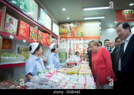 (HANDOUT) Ein undatiertes Handout zeigt Bundeskanzlerin Angela Merkel bei einem Besuch eines Marktes mit dem Schraubstock Bürgermeister (R) (Name unbekannt) auf Food Street in Tianjin, China. Foto: BUNDESREGIERUNG/GUIDO BERGMANN Stockfoto