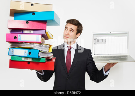 Geschäftsmann mit Stapeln von Ordnern und laptop Stockfoto