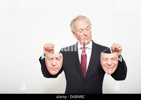 Geschäftsmann Holding Masken Stockfoto