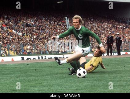 (Dpa Datei) - eine Archiv-Bild vom 18. Juni 1974, zeigt Spieler der deutschen Fußball-Kader, Uli Hoeneß, Grunde für den Ball mit australische Spieler James Mackay in der ersten Runde zweiten Gruppenspiel zwischen Deutschland und Australien während der Fußball-Weltmeisterschaft 1974 in Hamburg. Der ehemalige Manager und neuer Präsident des Fußball-Bundesligisten FC Bayern München Uli Hoeneß ist cele Stockfoto