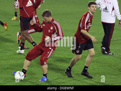 Bayern Bastian Schweinsteiger (L) läuft mit dem Ball neben seinem Teamkollegen Thomas Mueller während der ersten Trainingseinheit des Fußball-Bundesligisten FC Bayern München in Doha, Katar, 2. Januar 2012. München bereitet sich für das zweite Halbjahr 2011/2012-Bundesliga-Saison in Katar vom 2 Januar bis 9. Januar 2012. Foto: Karl-Josef Hildenbrand Stockfoto