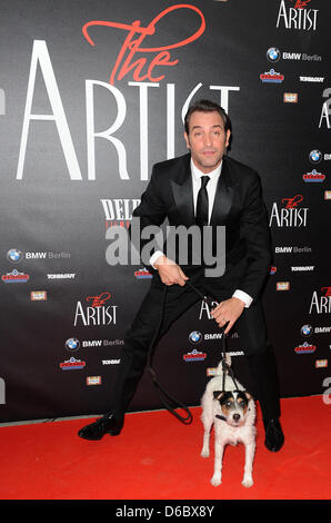 Französischer Schauspieler Jean Dujardin stellt mit seinem Hund auf dem roten Teppich bei der Delphi-Film-Palast anlässlich der Deutschlandpremiere des Films "The Artist" in Berlin, Deutschland, 3. Januar 2012. Der Film beginnt in den deutschen Kinos am 26. Januar 2012 zeigt. Die schwarz-weiß-Stummfilm ist eines der ist ein starker Anwärter für die Golden Globes. Foto: Britta Pedersen Stockfoto