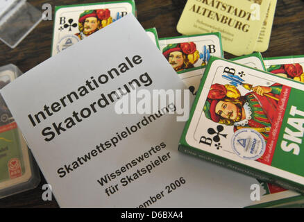 Datei - ILLUSTRATION - dieses Archiv Bild 3. Mai 2010 datiert zeigt eine Auswahl von Spielkarten mit einer Kopie der internationalen Skat Regeln auf einem Tisch im Tourismusbüro der Skat-Stadt Altenburg, Deutschland. 15 bis 20 Millionen Deutsche spielen Skat führt oft zu Auseinandersetzungen über die genaue Auslegung der Regeln des Spiels. In 2011 400 wurden mit der internationalen Anfragen eingereicht. Stockfoto