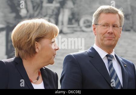 Datei - eine Archiv Bild datiert 13. August 2011 zeigt die deutsche Bundeskanzlerin Angela Merkel (CDU) und Bundespräsident Christian Wulff vor ein riesiges Bild von dem Bau der Berliner Mauer anlässlich des "50. Jahrestags des Baus der Mauer 1961" in der Gedenkstätte Bernauer Straße in Berlin, Deutschland. Merkel begrüßt Wulffs öffentlichen Äußerungen während einer tv Stockfoto
