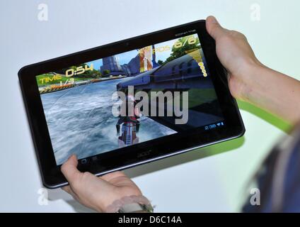 Ein Mitarbeiter von Acer präsentiert einen neuen Tabletcomputer der Serie Iconia durch Taiwan Computerunternehmen Acer zeigt eine Motorrad Rennsimulation auf der Consumer Electronics Show (CES) in Las Vegas, USA, 08 Jauary 2012.    Der Tablet-Computer ist mit einem Quad-Core-Prozessor ausgestattet deren erhöhte Rechenleistung Videos und Computerspiele profitieren werden. Das Tablet ist auch equi Stockfoto