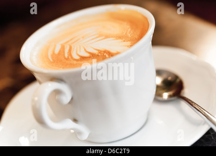 Cappuccino mit Gewürzen und künstlerische Schaum in eine weiße Tasse Kaffee Stockfoto