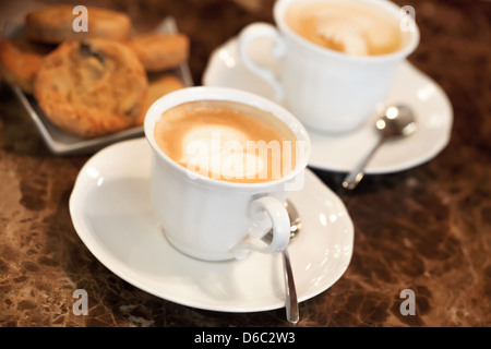 Zwei weiße Tassen Kaffee Cappuccino mit Milchschaum in Herzform. Selektiven Fokus Stockfoto