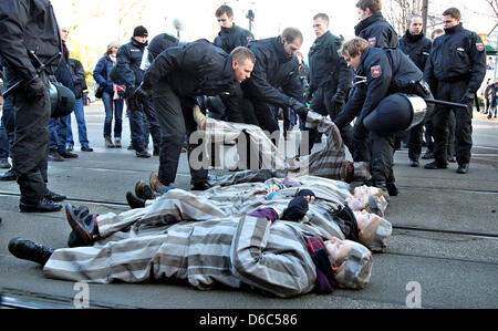 Polizisten klar eine Blockade von Demonstranten gegen die Neonazi-Rallye gekleidet als KZ-Häftlings in Magdeburg, Deutschland, 14. Januar 2012. Mehr als 1.000 Neonazis nahmen an einer Festschrift Kundgebung anlässlich der Bombardierung der Stadt Magdeburg am 16. Januar 1945. Rund 5.000 Menschen besuchten die Zähler-Demonstration gegen Rechtsextremismus zu protestieren. Pho Stockfoto