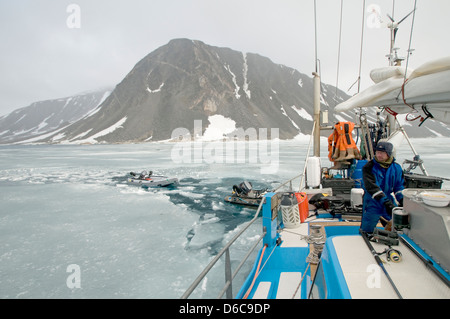 Segelboot mit Stahlschleppung im Eis in Svalbard, das im Sommer vor einem Sturm in der Hocharktis reitet. Stockfoto