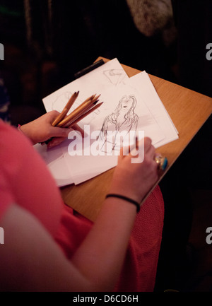 Mitglied sitzendem Publikum genießt eine Leistung und skizzieren an einen Dr. Sketchy Burlesque Aktzeichnen event Stockfoto