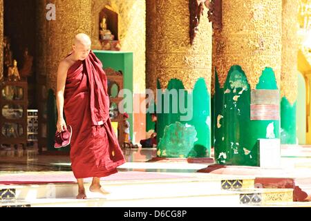 Ein Mönch in roten Spaziergänge an der Shwedagon-Pagode in Yangon, Myanmar, 6. Februar 2013. Stockfoto