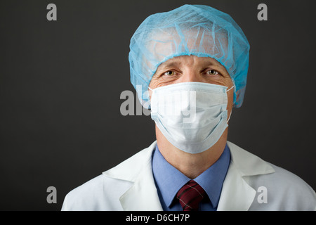 Männlichen Arzt in Maske und Mütze Stockfoto