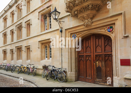 Oxford, Oxfordshire, England, UK. Pembroke College alte hölzerne Tür mit Fahrrädern an der Wand außerhalb Stockfoto