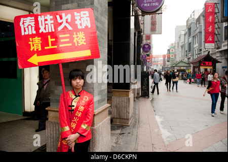 Guangzhou, China, jungen Chinesen mit ein Werbeschild Stockfoto