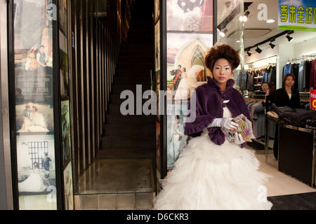 Guangzhou, China, junge Chinesin in einem Brautkleid Flugblätter verteilt Stockfoto