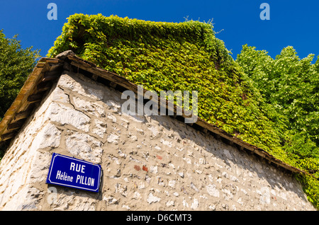 Straßenschild und Efeu an der Steinmauer, Giverny, Normandie, Frankreich Stockfoto