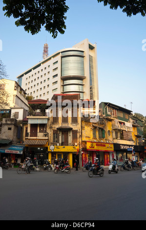 Vertikale Straßenbild der alten Stil röhrenförmigen Häuser und die neuen modernen Wolkenkratzer nebeneinander im Zentrum von Hanoi am Abend Stockfoto