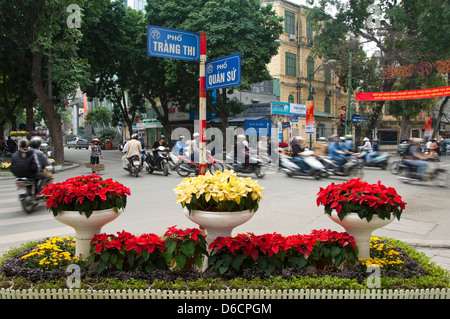 Horizontale Ansicht von Mopeds, das bevorzugte Transportmittel in Vietnam, fahren in alle Richtungen an einer belebten Kreuzung in Hanoi Stockfoto