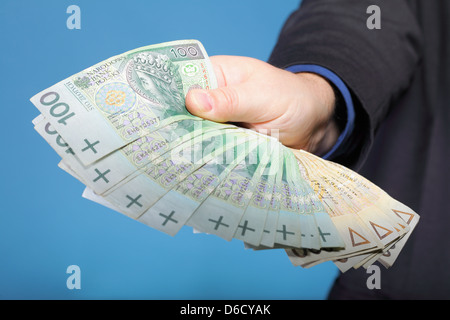 Das Unternehmer Hand mit Polnisch Geld Banknote blau Hintergrund Stockfoto