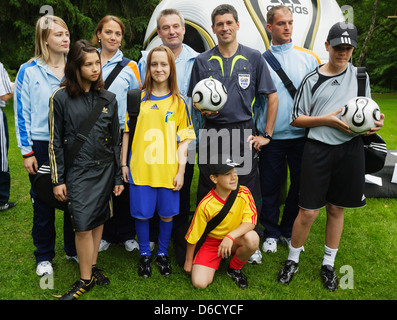 FRANKFURT, DEUTSCHLAND - 5. JUNI: FIFA-WM-Schiedsrichter Markus Merk (GER) hält den offiziellen Ball und steht mit Freiwilligen während einer Mediensitzung für Journalisten im Hotel Kempinski Gravenbruch am 5. Juni 2006 in Frankfurt. Nur redaktionelle Verwendung. (Foto: Jonathan Paul Larsen / Diadem Images) Stockfoto