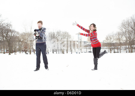 Mädchen werfen Schnee am Mann und Hund im park Stockfoto