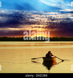 Paar im Boot gegen einen wunderschönen Sonnenuntergang Stockfoto