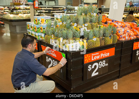 Sterling Heights, Michigan - ein Arbeiter ersetzt Zeichen in der Gemüseabteilung Abschnitt eines Walmart-Store. Stockfoto