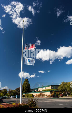 Die amerikanische Flagge und die amerikanischen Golf Fahne fliegen auf Halbmast außerhalb Tony Lema Golf Course, ein städtischer Kurs in San Leandro, Kalifornien, über 3.000 Meilen weg von Boston, Massachusetts und der Boston-Marathon Bombardierung. Stockfoto