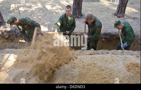 Deutsche und russische Soldaten graben ein Grab für die Übertragung der Überreste der deutschen Soldaten aus dem zweiten Weltkrieg auf dem Holz Friedhof in Halbe, Deutschland, 6. September 2012. Versöhnung über den Gräbern: junge deutsche und russische Soldaten tot deutsche und russische Soldaten aus dem zweiten Weltkrieg zusammen begraben werden. Die Übertragung der Überreste statt findet am Lebus auf 12. September 2012 und 13 Septemb Stockfoto