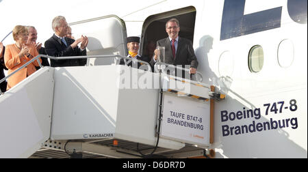CEO der Lufthansa Christoph Franz (2 L) und die deutsche Bundeskanzlerin Angela Merkel (L) klatscht nach Premier von Brandenburg Matthias Platzeck eine Boeing 747-8 mit dem Namen "Brandenburg" auf der International Air Show ILA am Flughafen Berlin-Schönefeld in Schönefeld, Deutschland, 11. September 2012 tauft. Die Flugschau auf dem Flughafen südlich von Berlin wird vom 11. bis 16. September 2012 stattfinden. PH Stockfoto