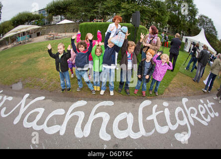 Kinder aus einer Kindertagesstätte im Stadtteil Sachsenhausen stehen vor der Schrift "Nachhaltigkeit" ("Nachhaltigkeit"), gemalt von einem Künstler auf dem Bürgersteig an den Ufern des Flusses in Frankfurt Main, Deutschland, 12. September 2012. Eine Woche vor dem 2. Tag der Nachhaltigkeit in Hessen, der Umweltminister von Hessen Puttrich besucht der Riesens, grüne "MainSofa" aus fr Stockfoto