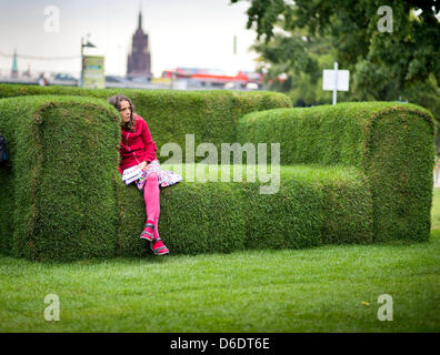 Ein Passant sitzt auf einem Sofa gemacht Gras in Frankfurt Main, Deutschland, 12. September 2012. Eine Woche vor dem 2. Tag der Nachhaltigkeit in Hessen, der Umweltminister von Hessen Puttrich besucht der Riesens, grüne "MainSofa" aus Gras-, Stroh und Sisal. Es werden Veranstaltungen und Kampagnen quer durch den Staat zum Thema. Foto: Frank Rumpenhorst Stockfoto