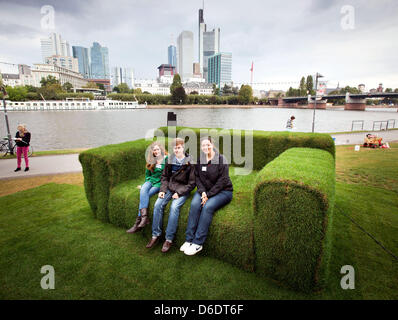 Eva Zimmermann (L-R), Hans-Martin Reissner und Dragana Gerovac sitzen auf einem Sofa gemacht Gras in Frankfurt Main, Deutschland, 12. September 2012. Eine Woche vor dem 2. Tag der Nachhaltigkeit in Hessen, der Umweltminister von Hessen Puttrich besucht der Riesens, grüne "MainSofa" aus Gras-, Stroh und Sisal. Es werden Veranstaltungen und Kampagnen quer durch den Staat zum Thema. Foto: Fran Stockfoto