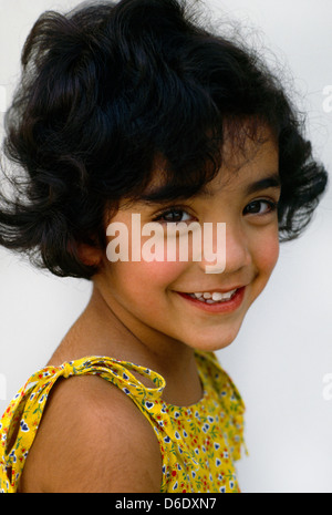 6 Jahre altes Mädchen mit dunklen Haaren seitwärts Pose Stockfoto
