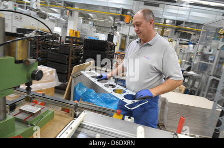 Ein Mitarbeiter des deutschen Autos Ersatzteile Teile-Hersteller arbeitet ElringKlinger auf eine Zylinderkopfdichtung in Dettingen ein der Erms, Deutschland, 7. September 2012. Foto: Franziska Kraufmann Stockfoto