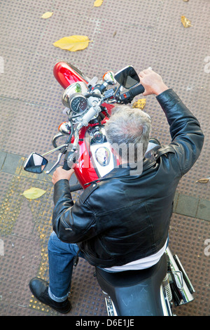 Luftaufnahme der Motorradfahrer unter die linke Hand wiederum auf ein rotes Fahrrad Stockfoto