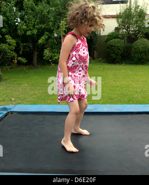 Mädchen springen auf dem Trampolin im Garten Englands Stockfoto