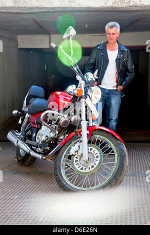 Rot Cruiser Motorrad und seine fürsorglichen Bewunderer. Kaukasische Modell und generische Foto wurde aufgenommen in Bombay Indien Stockfoto