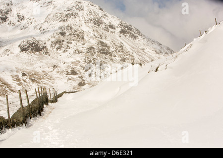 Massive Schnee driftet Block Kirkstone Pass-Straße oberhalb Ambleside im Lake District, Stockfoto